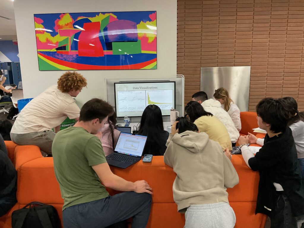 DH101 Final Project Showcase; students demonstrating their final projects around screen in YRL library